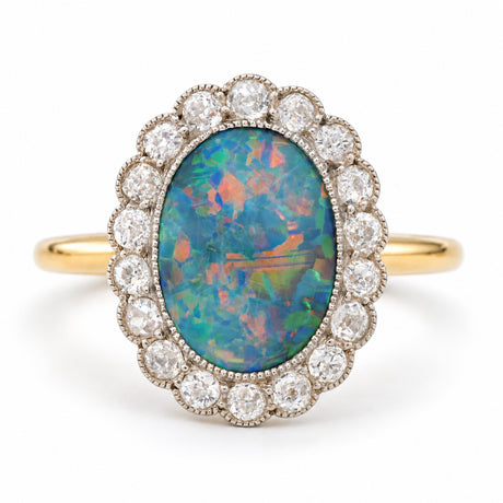 Antique Edwardian black opal and diamond cluster ring in yellow gold and platinum, featuring vivid blue, green and orange play of colour.