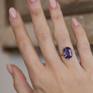 Antique purple sapphire solitaire ring worn on a hand, showcasing its striking gemstone and elegant proportions.