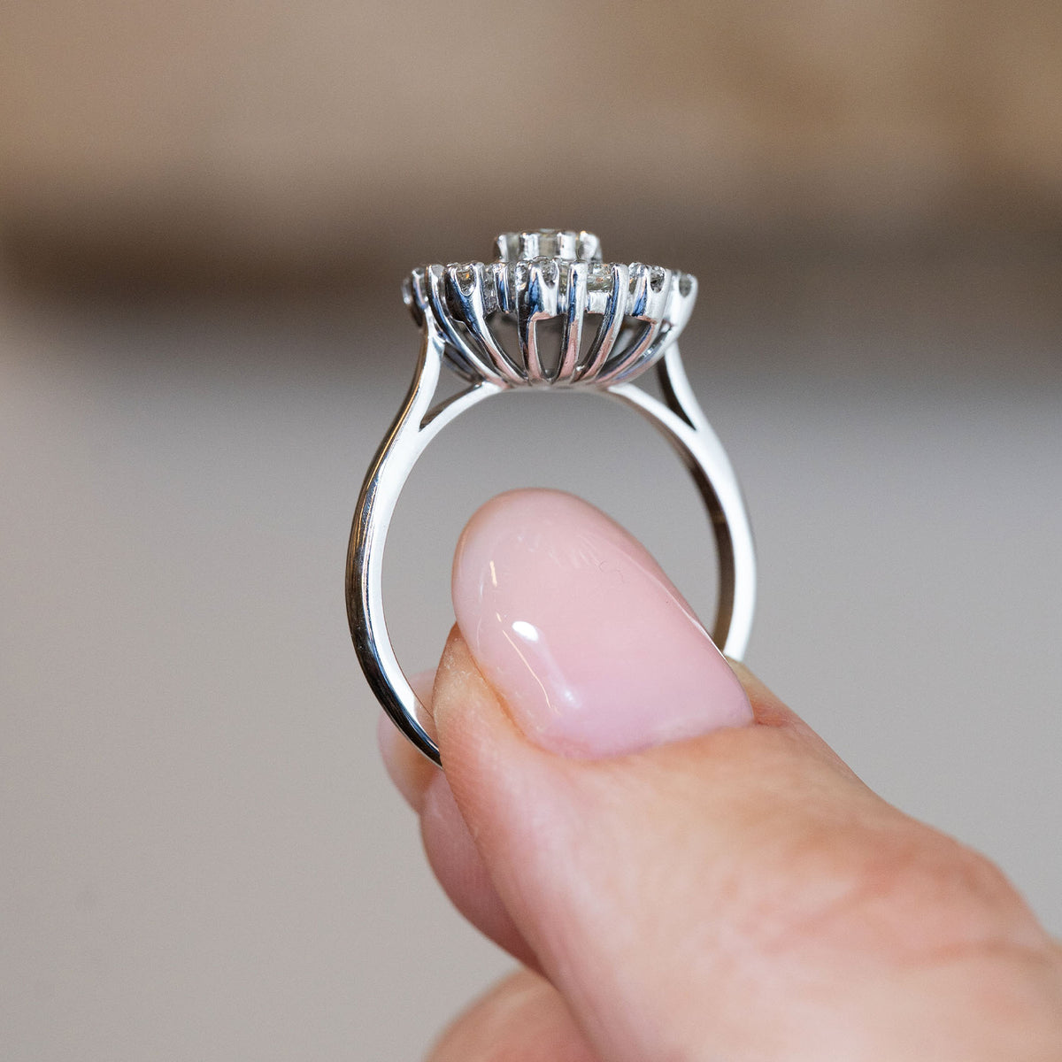 Side profile of the vintage diamond engagement ring, revealing the raised basket setting and elegant white gold band.