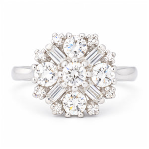 Vintage 1980s diamond cluster engagement ring in white gold, featuring round brilliant-cut and baguette-cut diamonds in a floral-inspired design.