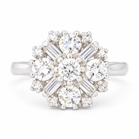 Vintage 1980s diamond cluster engagement ring in white gold, featuring round brilliant-cut and baguette-cut diamonds in a floral-inspired design.