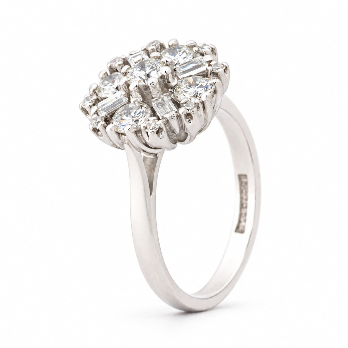 Angled view of the vintage diamond cluster ring, highlighting the raised setting and intricate arrangement of round and baguette diamonds.