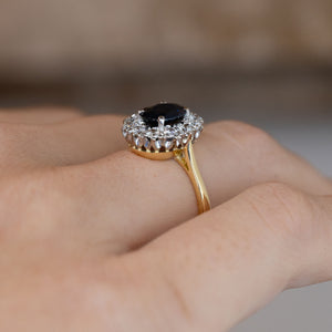 Side-angle view of the 1940s sapphire engagement ring worn on a hand, highlighting the elevated platinum setting and delicate gold band.