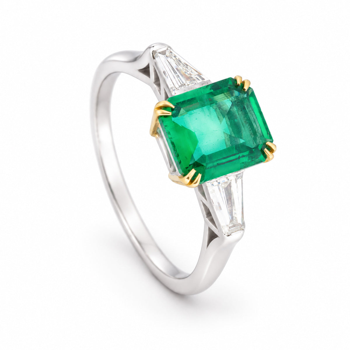 Three-quarter studio portrait of the vintage emerald ring, revealing its raised setting, tapered diamond sides and contrasting gold claws.