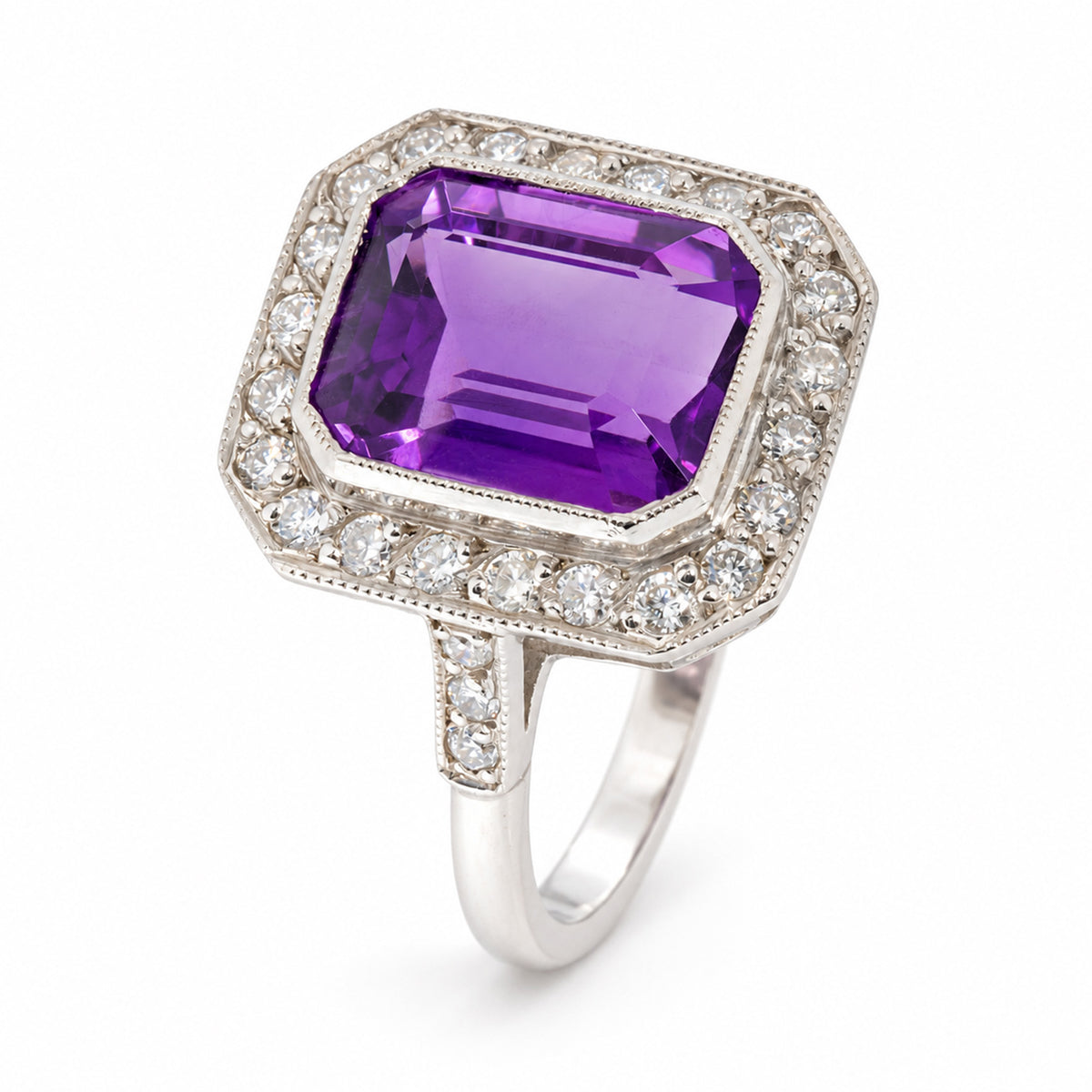 Angled view of an antique Art Deco amethyst and diamond cluster ring in white gold, showcasing its vibrant purple amethyst, octagonal diamond surround and diamond-set shoulders.