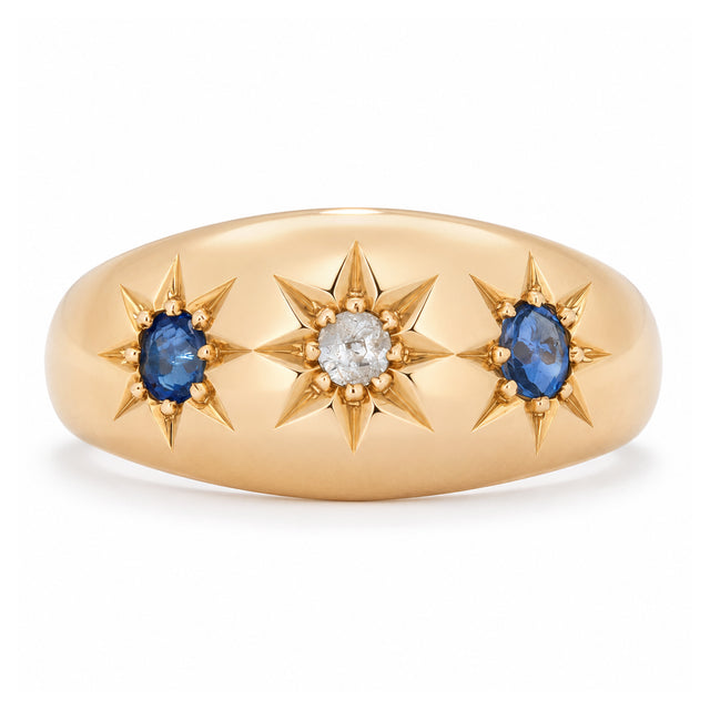 Antique Edwardian sapphire and diamond three-stone gypsy ring in yellow gold, featuring two blue sapphires and a central diamond in star settings.