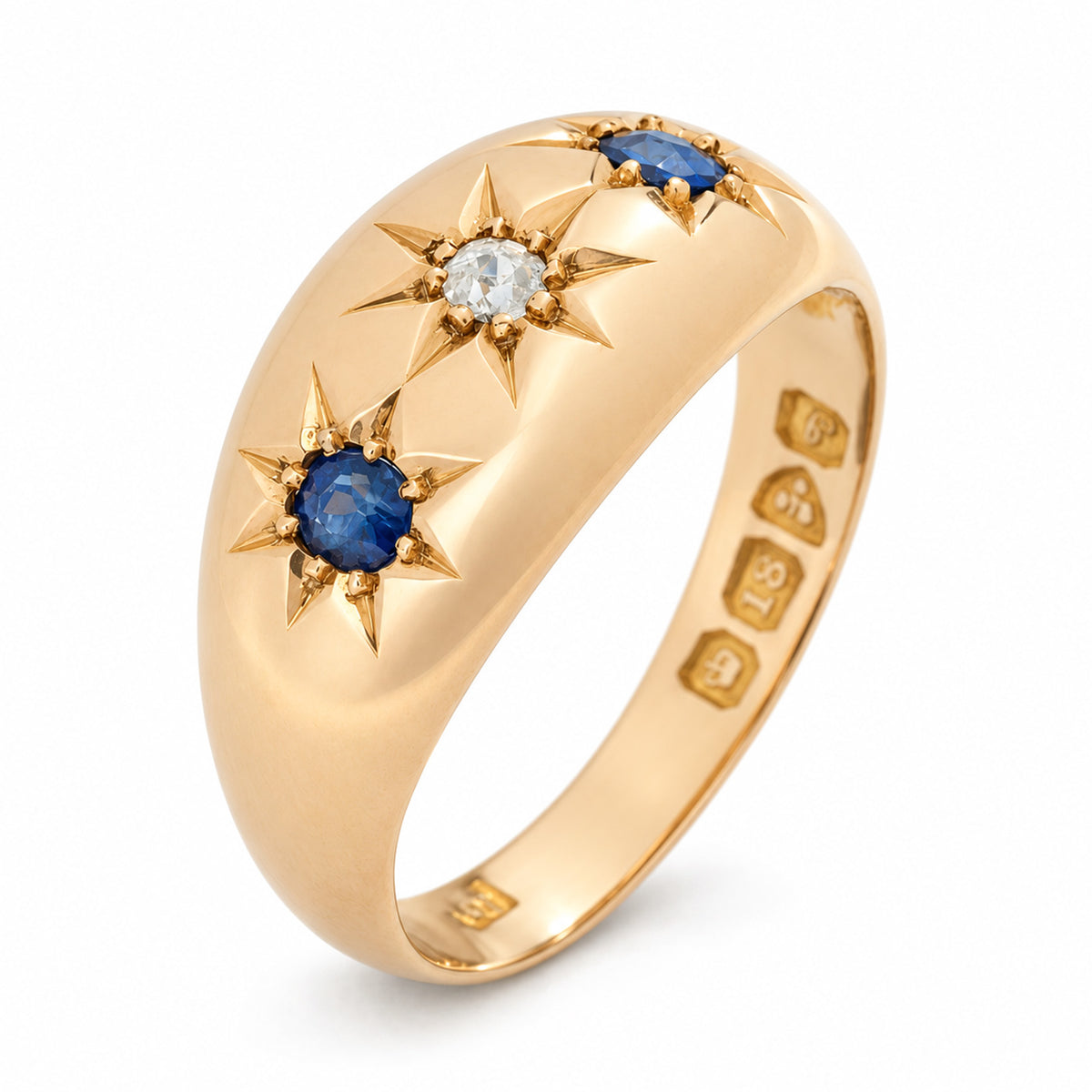 An angled photograph of the Edwardian gypsy ring, showcasing its polished gold band and decorative star-set gemstones.