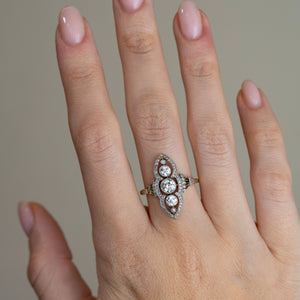 Antique Art Nouveau diamond cluster ring worn on a hand, highlighting its distinctive elongated shape and sparkling vintage diamonds.