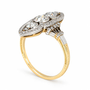 Angled studio view showcasing the intricate openwork setting, raised diamond arrangement and contrasting platinum and yellow gold band.