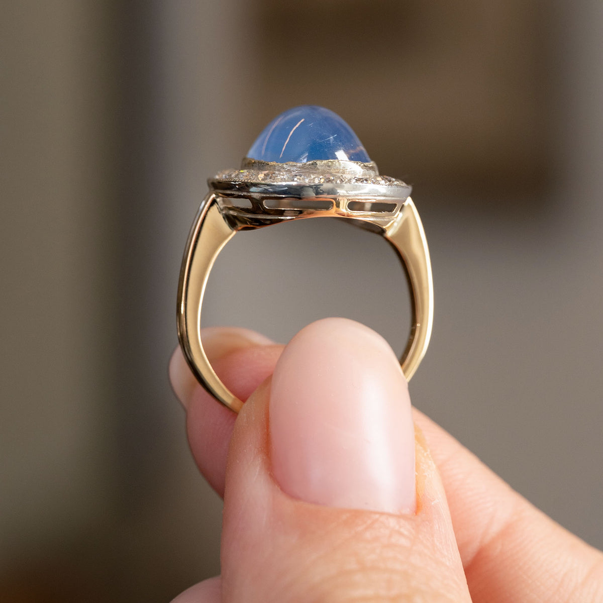 Profile view of the Victorian cluster ring, displaying the raised sapphire, silver setting and substantial yellow gold shank.