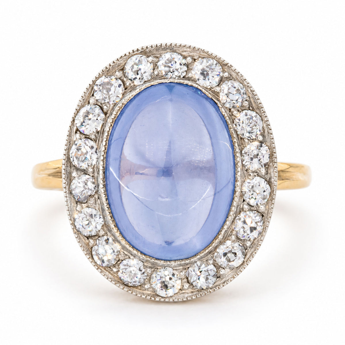 Antique Victorian cabochon-cut blue sapphire and diamond cluster ring, crafted in yellow gold with a silver-set diamond surround.