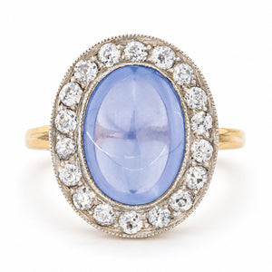 Antique Victorian cabochon-cut blue sapphire and diamond cluster ring, crafted in yellow gold with a silver-set diamond surround.