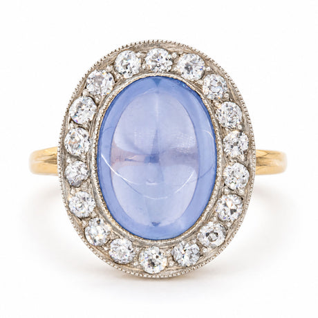 Antique Victorian cabochon-cut blue sapphire and diamond cluster ring, crafted in yellow gold with a silver-set diamond surround.