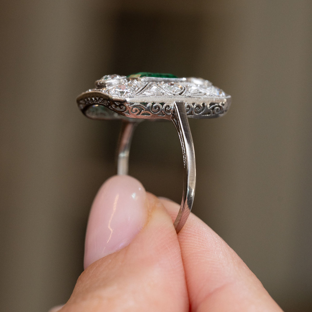 Profile of the Art Deco platinum ring, showing its low panel setting, pierced gallery and fine filigree decoration.