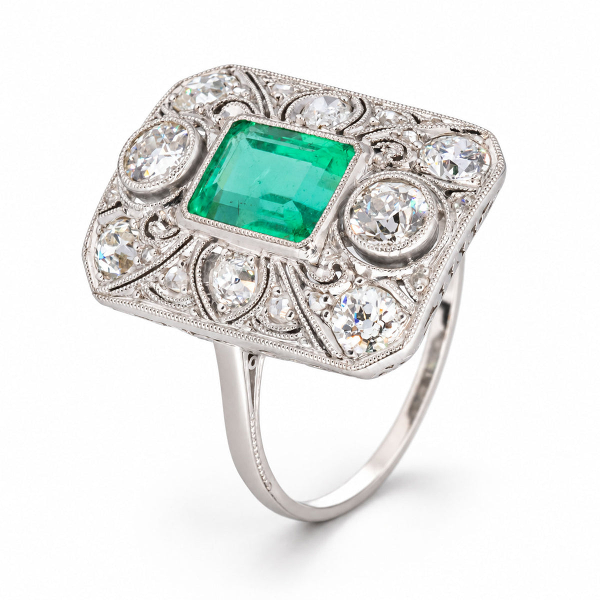 Three-quarter studio view of the antique platinum ring, showcasing its rectangular panel, vivid Colombian emerald and openwork diamond setting.