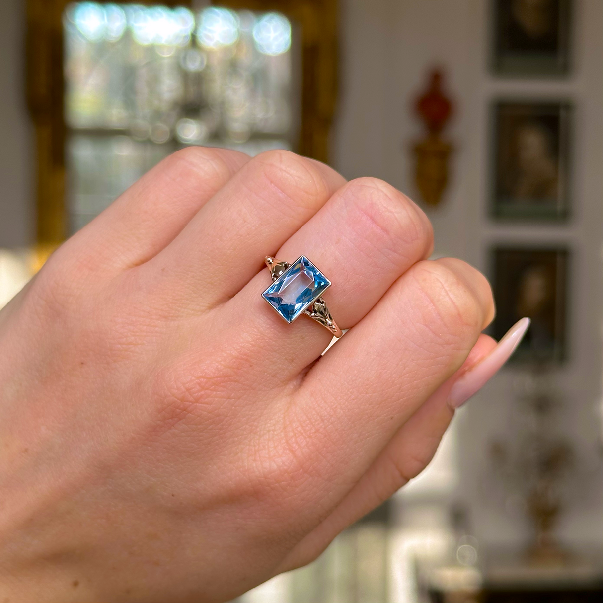 antique aquamarine single stone ring worn on closed hand .