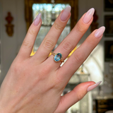 antique oval cut aquamarine singe stone ring worn on hand.