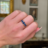 sapphire and diamond five stone ring on closed hand. 