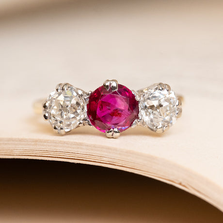 Antique Edwardian Burmese ruby and diamond three-stone ring, with a central ruby flanked by old-mine cut diamonds. 
