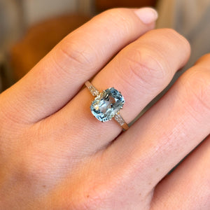 Antique Edwardian cushion-cut aquamarine and diamond engagement ring worn on the engagement ring finger, showcasing its elegance and fit.