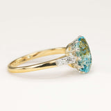 Antique Edwardian cushion-cut aquamarine and diamond engagement ring resting on a neutral surface, showing the aquamarine centre and diamond accents.