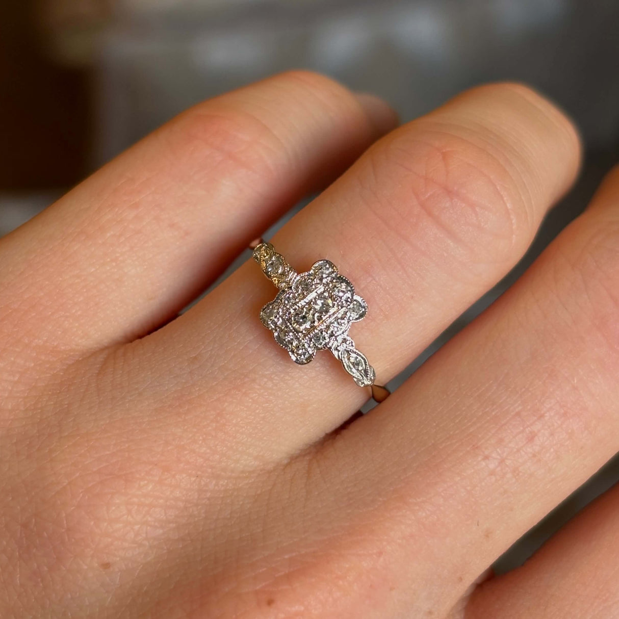 Antique, Edwardian diamond panel cluster engagement ring worn on hand close up
