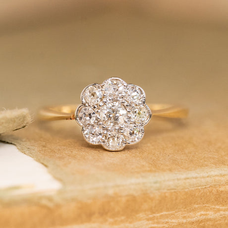 A dainty antique, Edwardian old-cut diamond cluster gold ring with a bezel setting. 