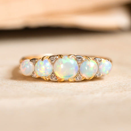 An Antique Edwardian five-stone opal and diamond ring set in yellow gold. 