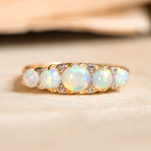 An Antique Edwardian five-stone opal and diamond ring set in yellow gold. 