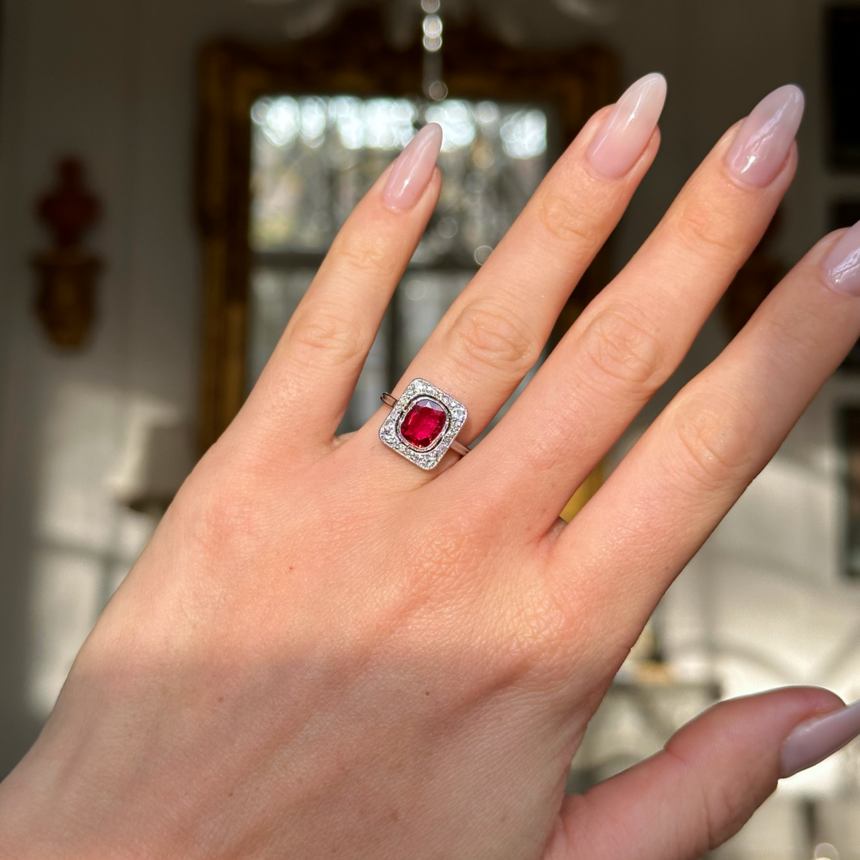 Vintage Art Deco ruby and diamond engagement ring worn on hand.