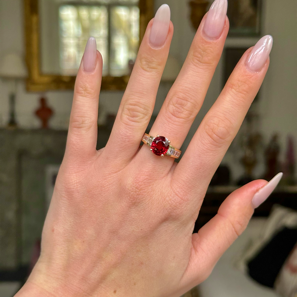 Art Deco spinel and diamond ring worn on hand. 