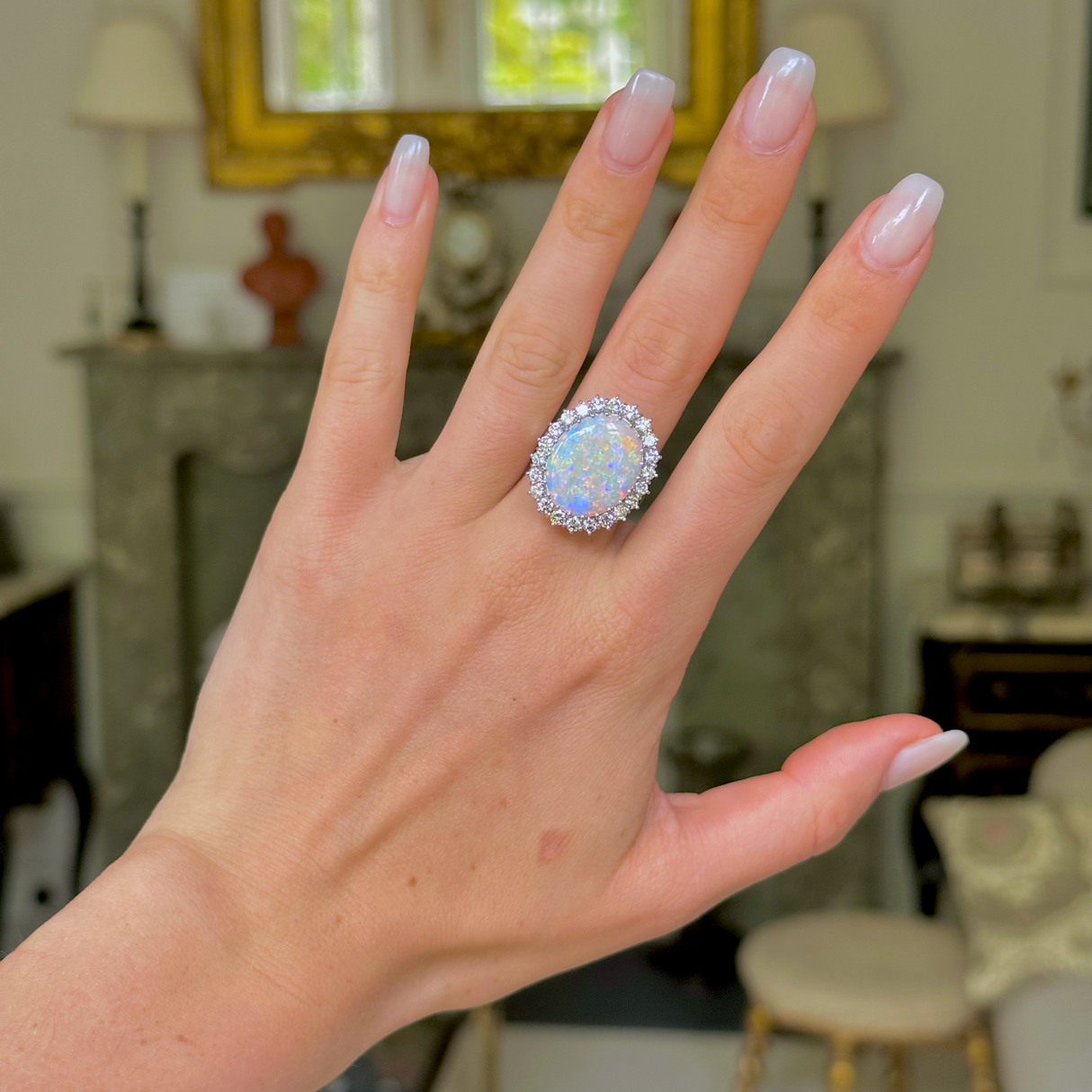 White opal and diamond cluster ring,  worn on hand.