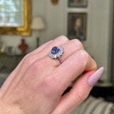 cabochon sapphire and diamond cluster ring on closed hand 