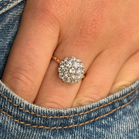 1980s diamond cluster engagement ring, worn on hand in pocket of jeans.