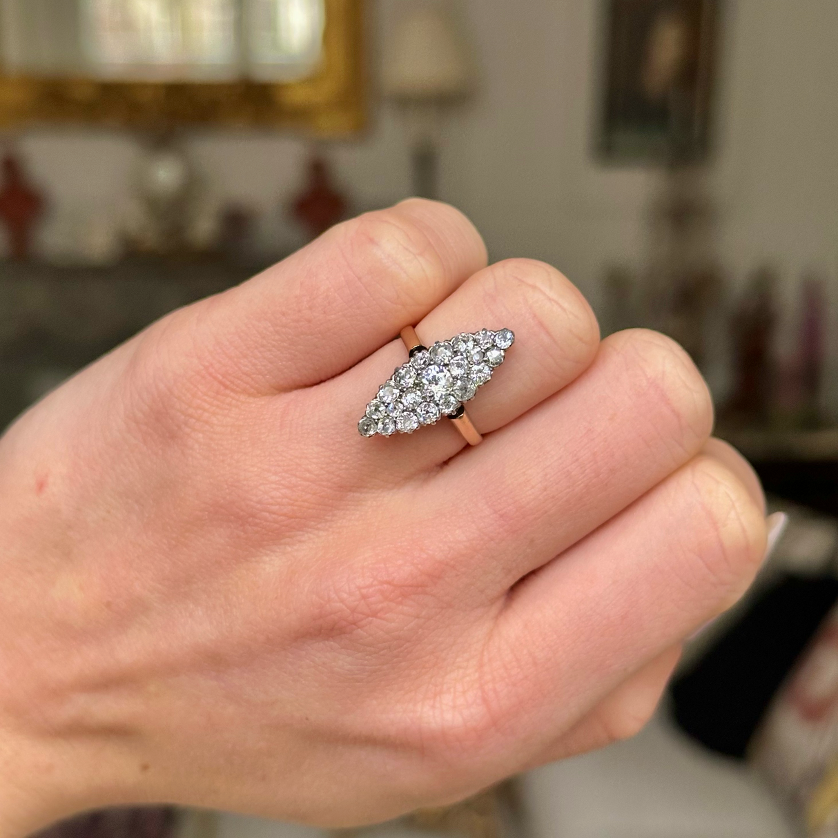 Antique diamond navette ring worn on closed hand. 