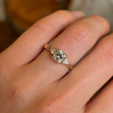Diamond three-stone engagement ring worn on hand closeup