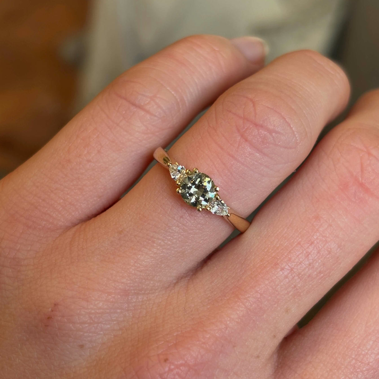 Diamond three-stone engagement ring on hand close up to show details