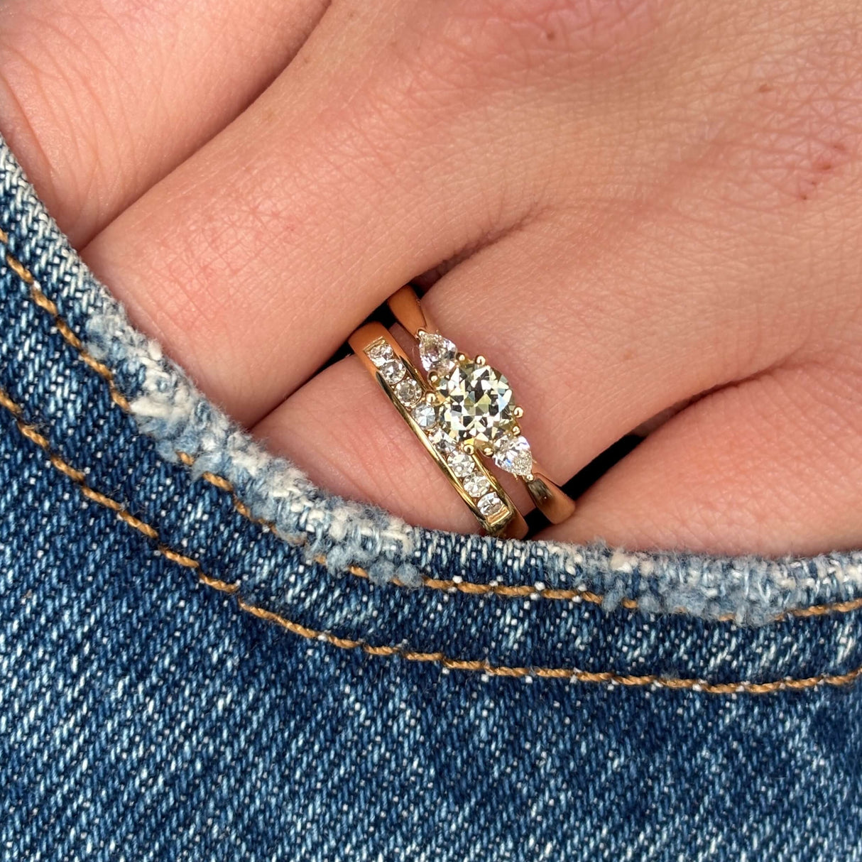 Diamond three-stone engagement ring worn with a wedding band to show fit and proportions 