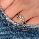 Diamond three-stone engagement ring worn with a wedding band to show fit and proportions 