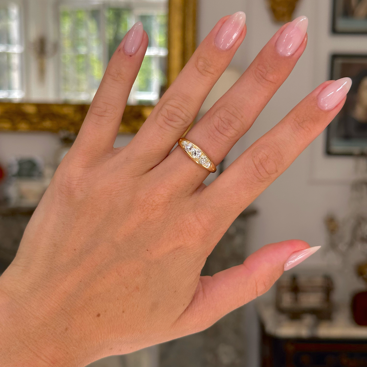 Antique five stone diamond engagement ring, worn on hand, front view.