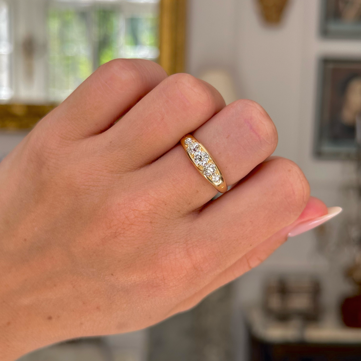 Antique five stone diamond engagement ring, worn on closed hand, front view.