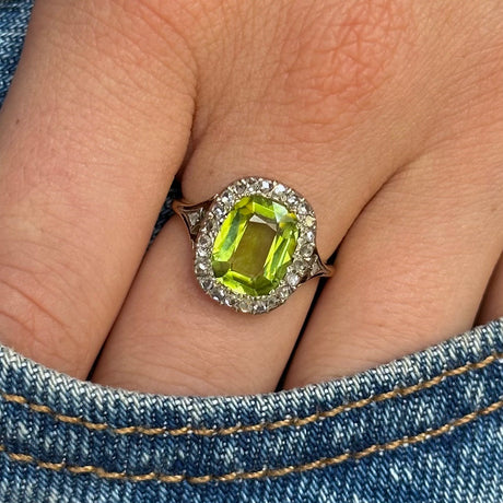 antique peridot and diamond ring, worn on hand in pocket of jeans,  front view.