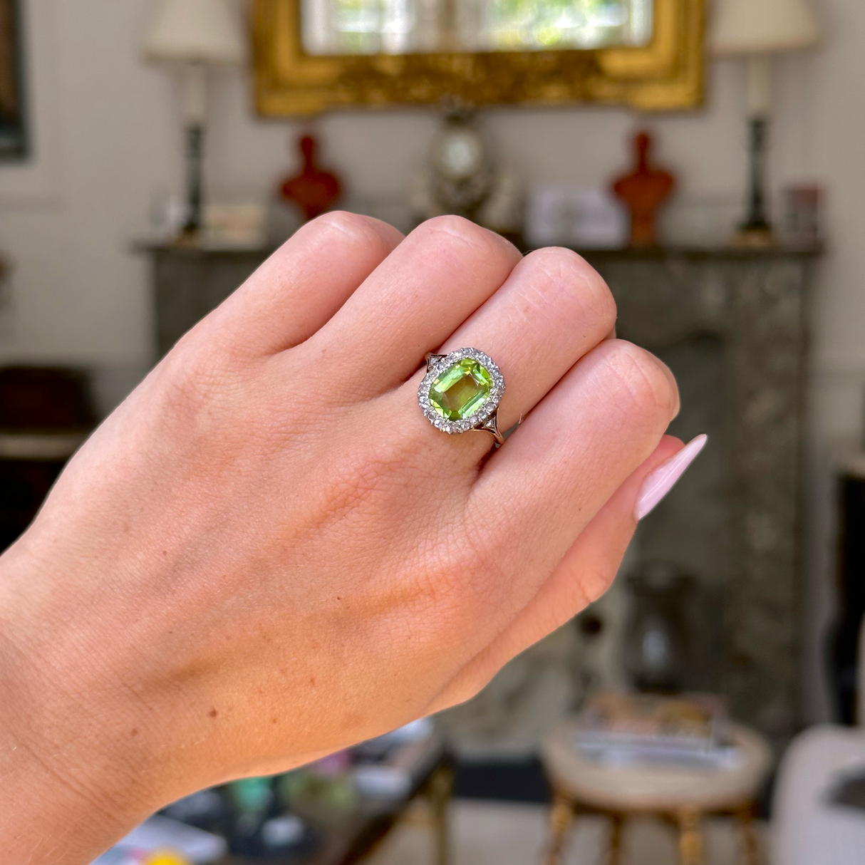 antique peridot and diamond ring, worn on closed hand, front view.