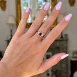 antique ruby and diamond cluster, worn on hand, front view.