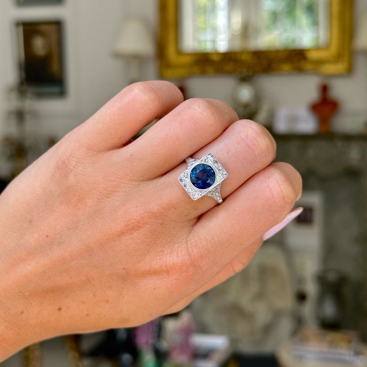 sapphire and diamond panel ring worn on closed hand. 