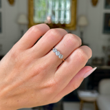 antique three stone diamond engagement ring, 18ct yellow gold band, worn on closed hand,  front view. 