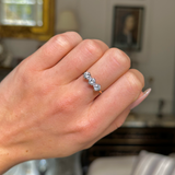 three stone diamond engagement ring, worn on closed hand, front view.