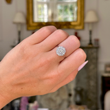 edwardian diamond daisy cluster engagement ring, worn on closed hand,  front view. 