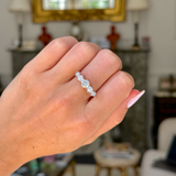 Antique five stone diamond ring worn on closed hand. 