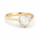 A three-quarter antique-inspired, yellow-toned cushion-cut diamond solitaire ring in yellow gold.